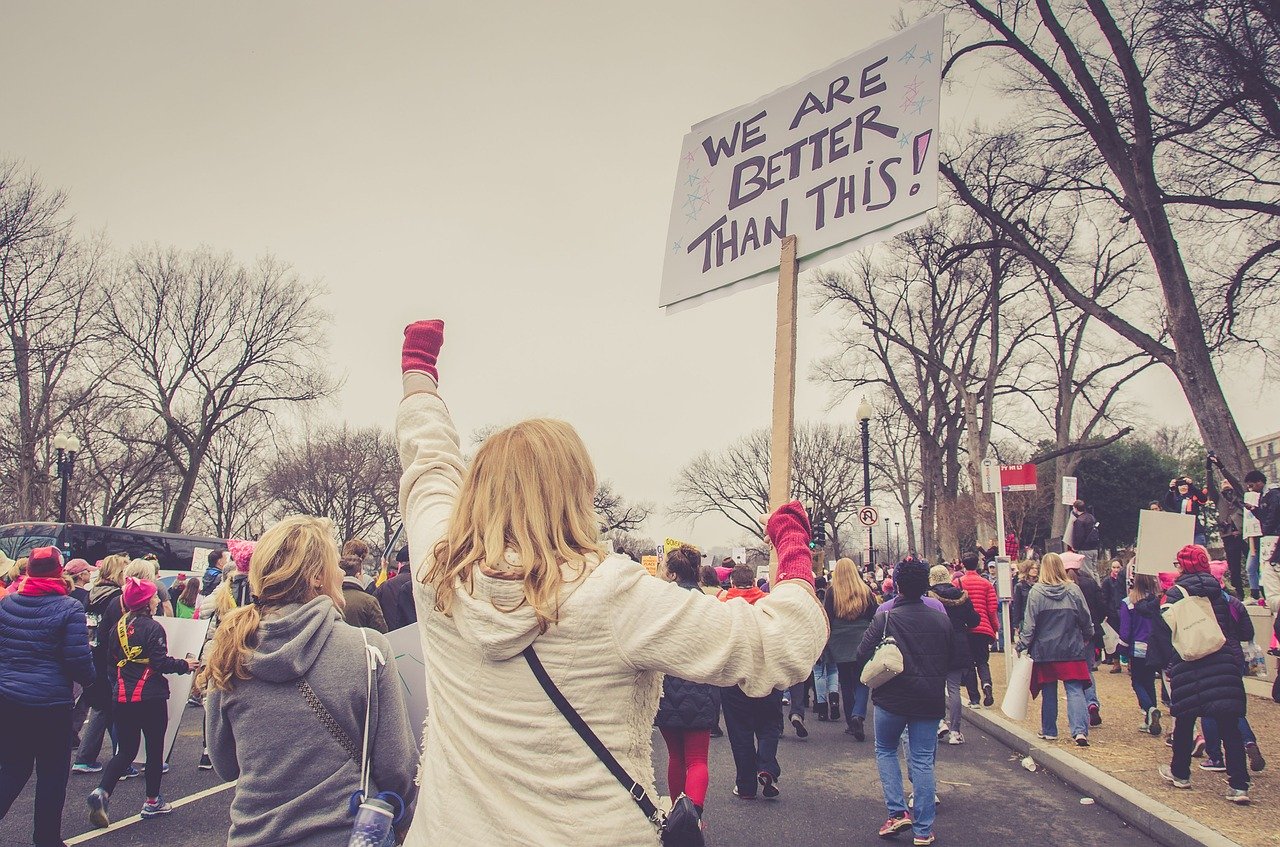 Woman holding a protest sign for change.